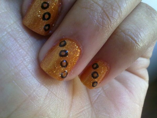 Unghii cu sclipici portocalii cu puncte maro și negre