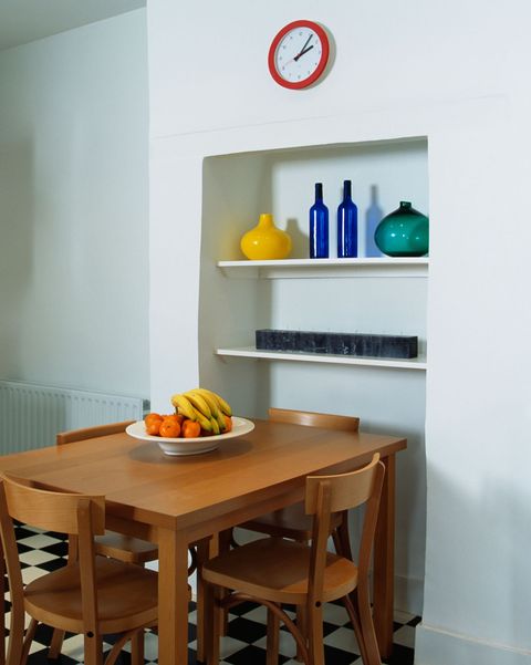 idei de alcovă, masă simplă din lemn și scaune în bucătăria modernă albă, cu pardoseală din negru alb