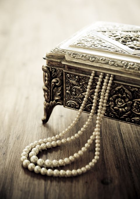 cutie de bijuterii și colier de perle, pe masă din lemn