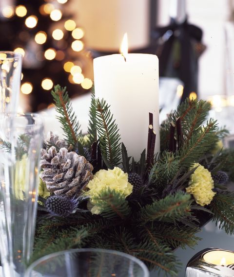 čiernobiele vianočné ozdoby do domácnosti so striebornou a forstovanou fialkou, jedálenský stôl so stredom sviečky z čerstvého rezaného konára, šišiek a karafiátov