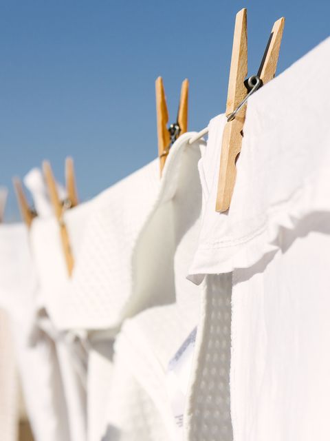 bela oblačila, sušena na pralni liniji na svetlem toplem sončnem ozadju, so čisto modro nebo