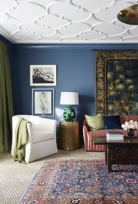 cameră de zi, perete vopsit în albastru, canapea roșie, covor texturat și covor