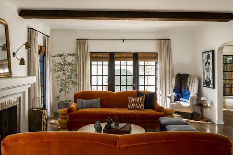 dnevna soba, oranžni kavč, bele stene, bele zavese